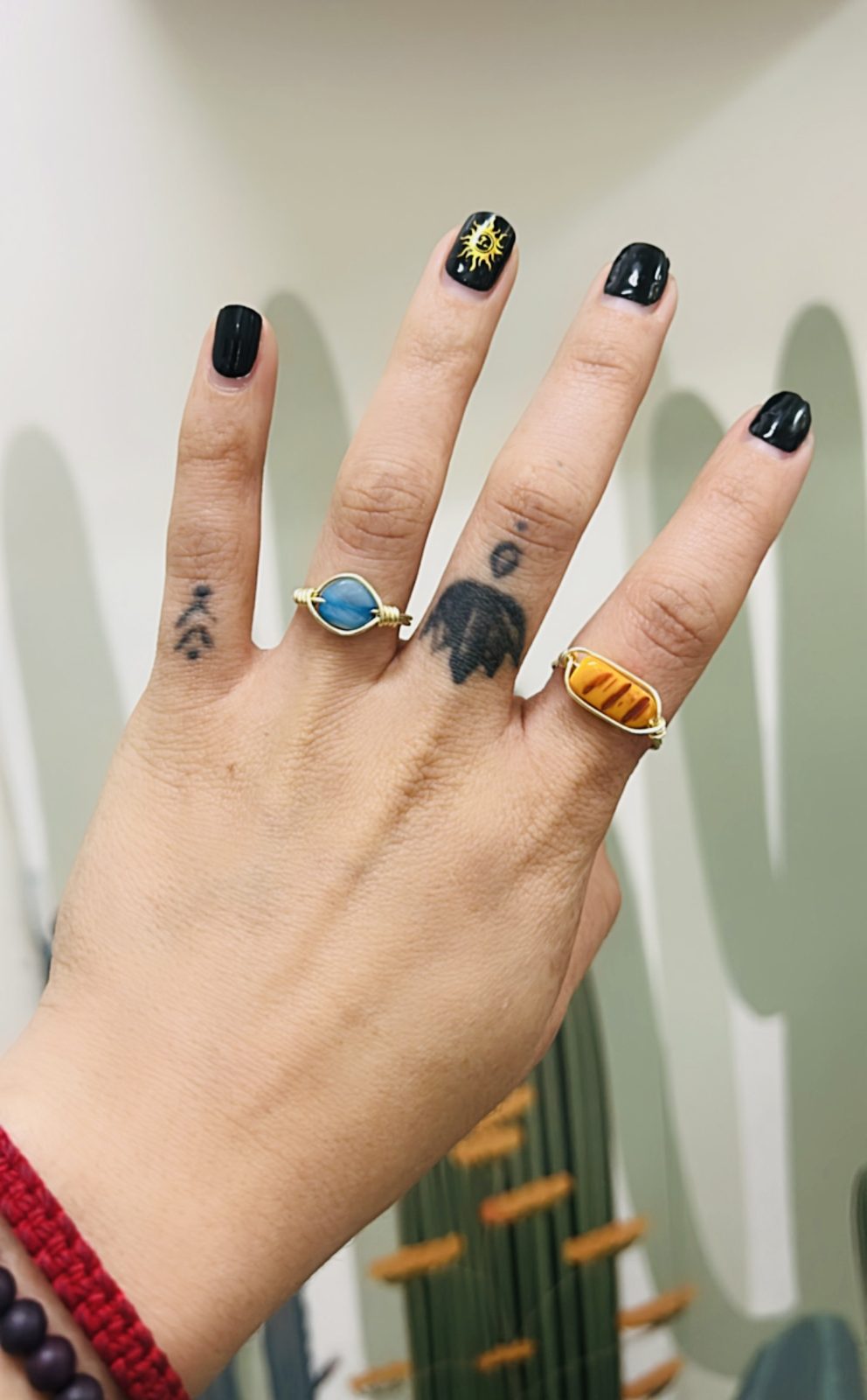 Anillos artesanales de alambre dorado con piedras azul y ámbar