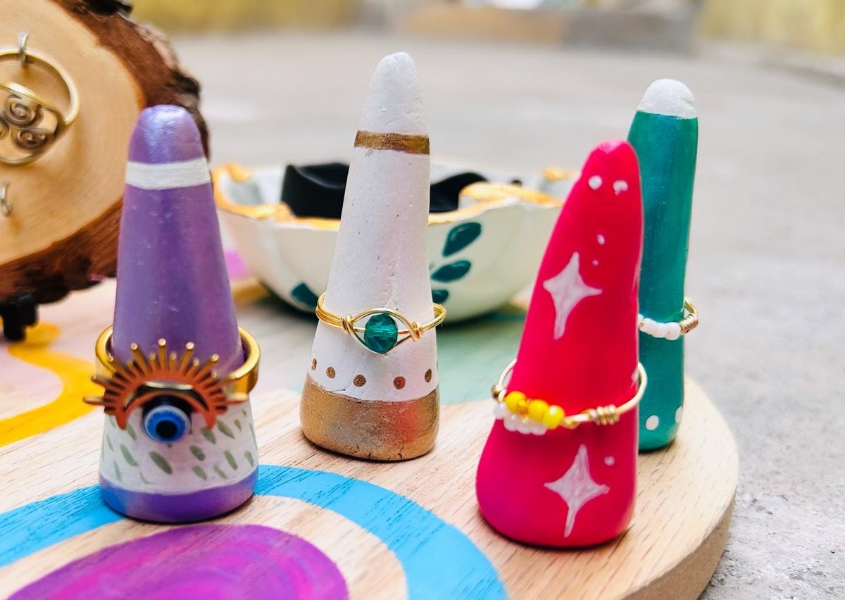 Anillos artesanales sobre conos exhibidores pintados a mano