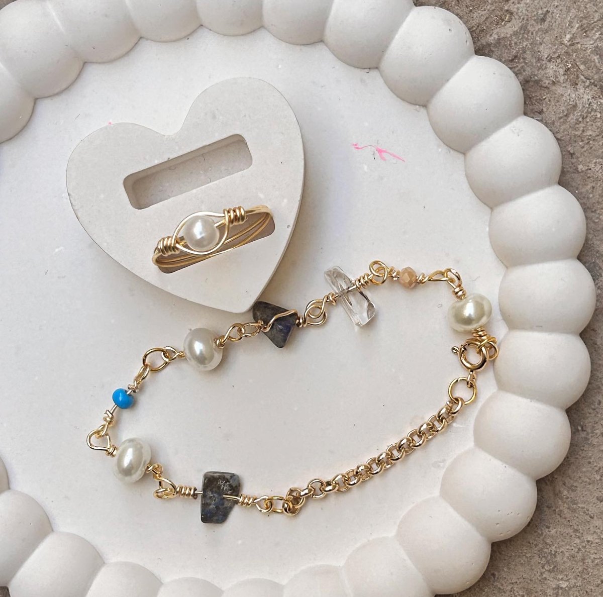 Pulsera dorada con perlas, cuarzo y lapislázuli junto a anillo de perla