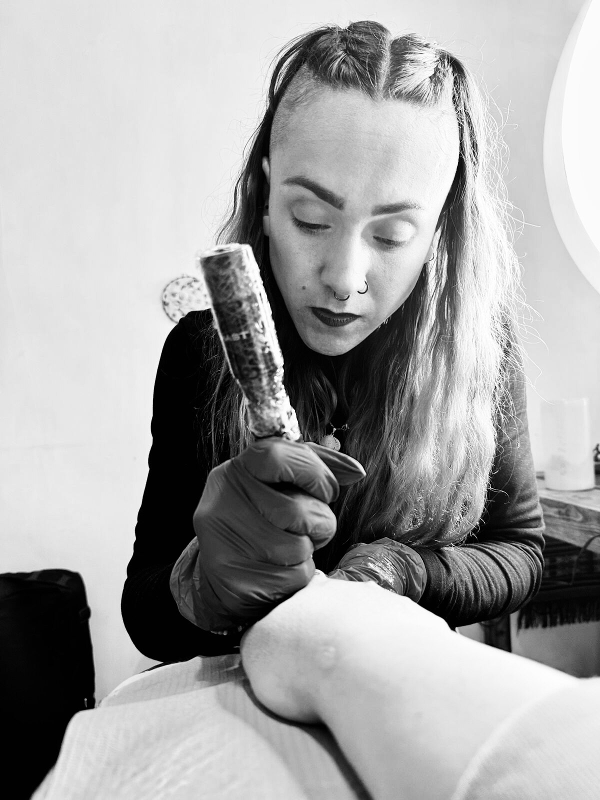 Karen Soltero tatuando en Alma Lila Tattoo Studio, retrato en blanco y negro